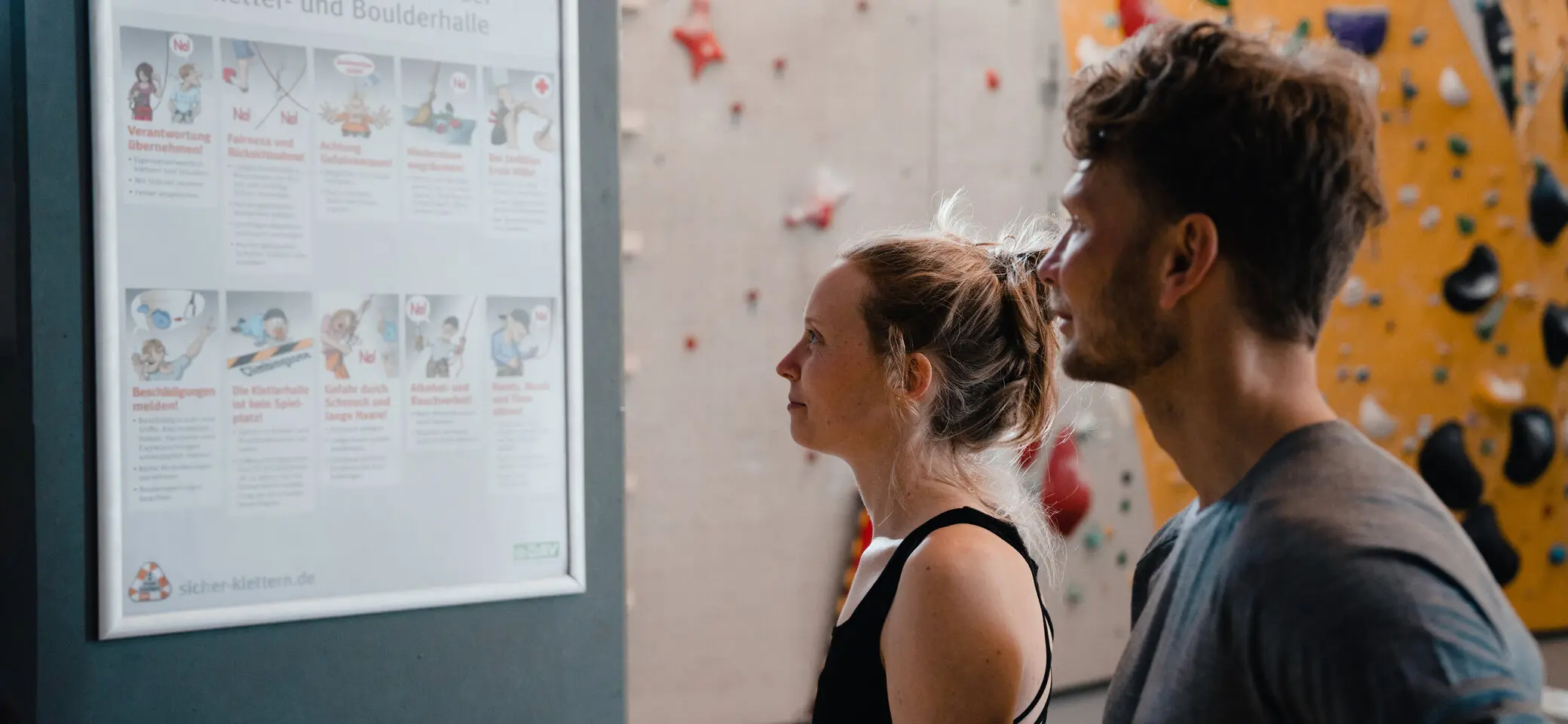 Zwei Personen checken den Trainingsplan, der an einer Wand hängt | © DAV/Marisa Koch